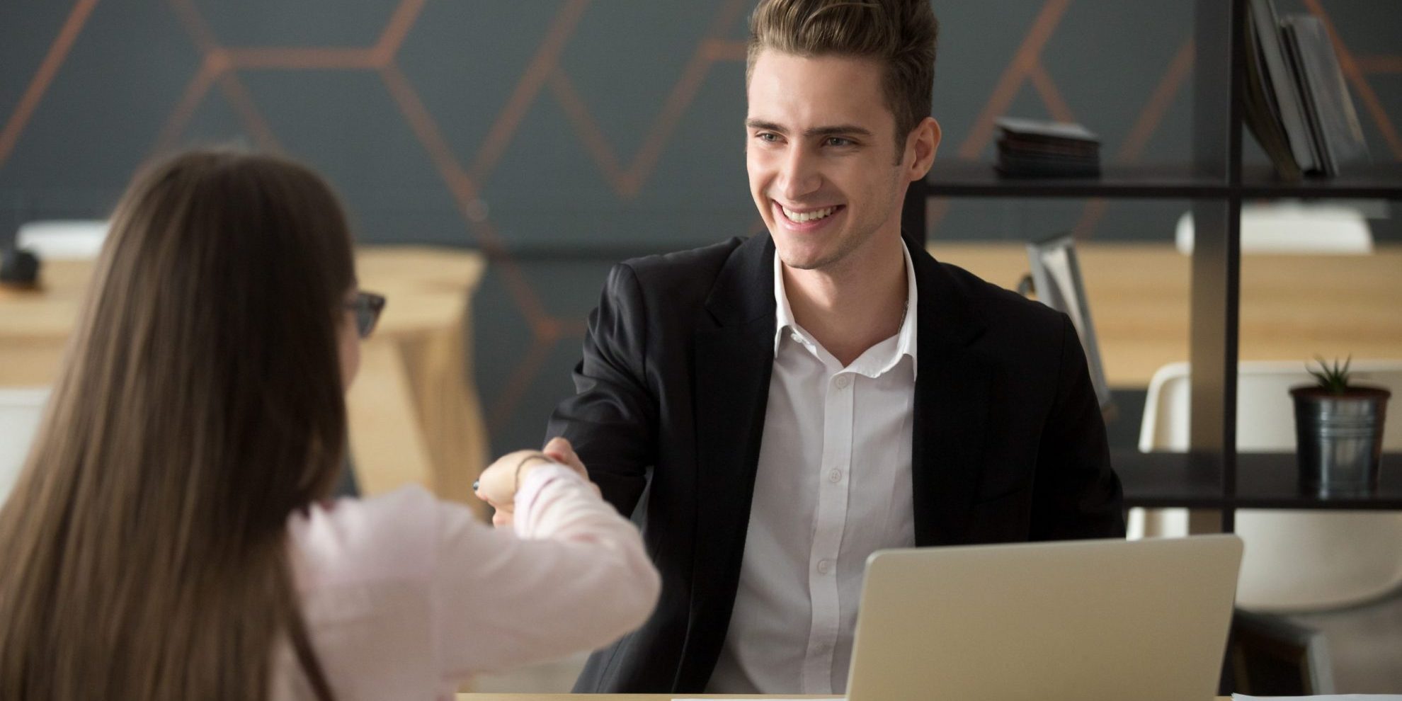 Photo of man and woman shaking hands illustrates blog: "Hiring Bias: What It Is and How to Reduce It"
