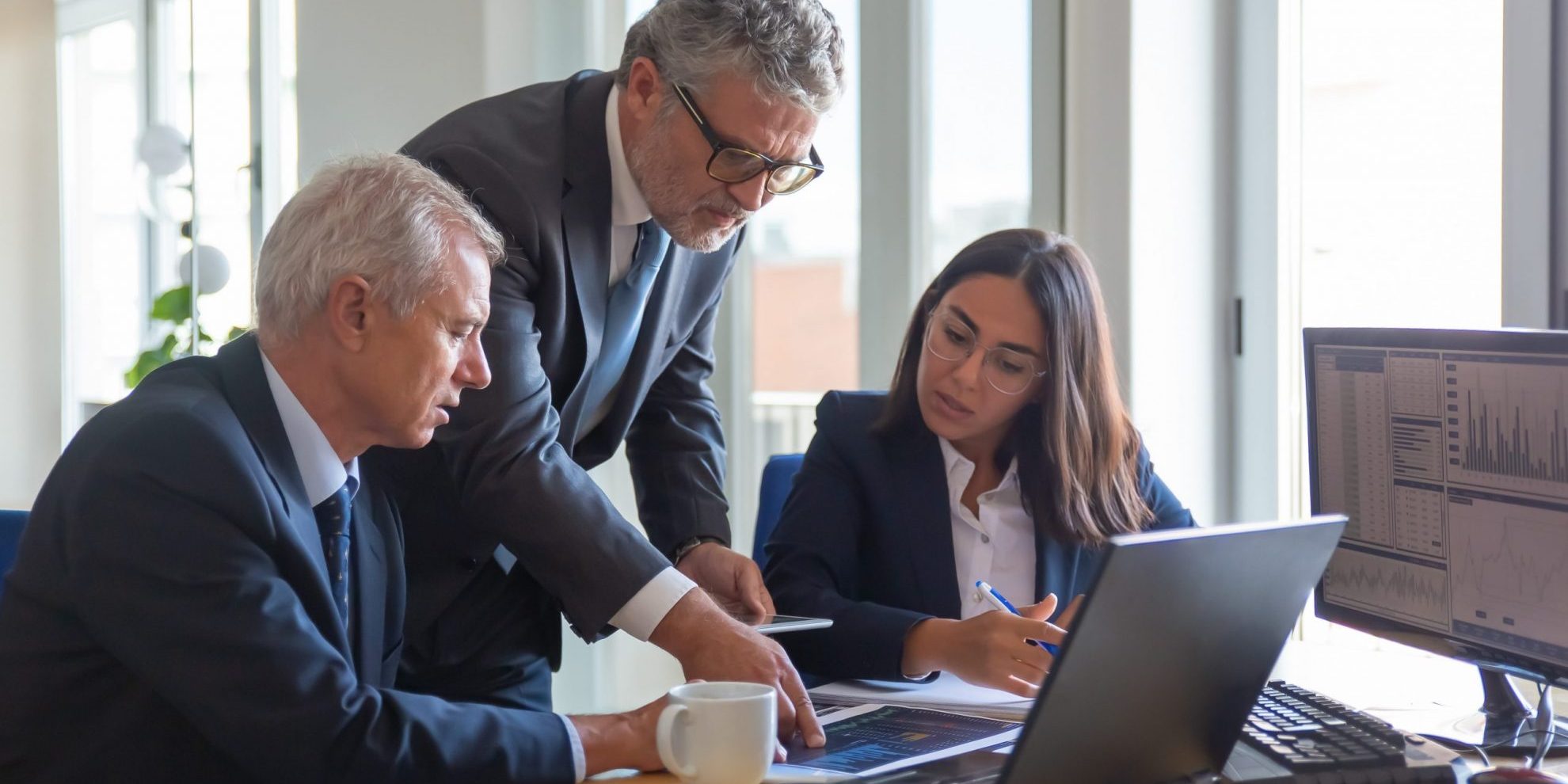 Photo of workers sitting at desk illustrates blog: "From the Great Resignation to the Great Retirement: the Job Trends You Need to Know"