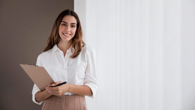 Photo of female administrative assistant with clipboard.
