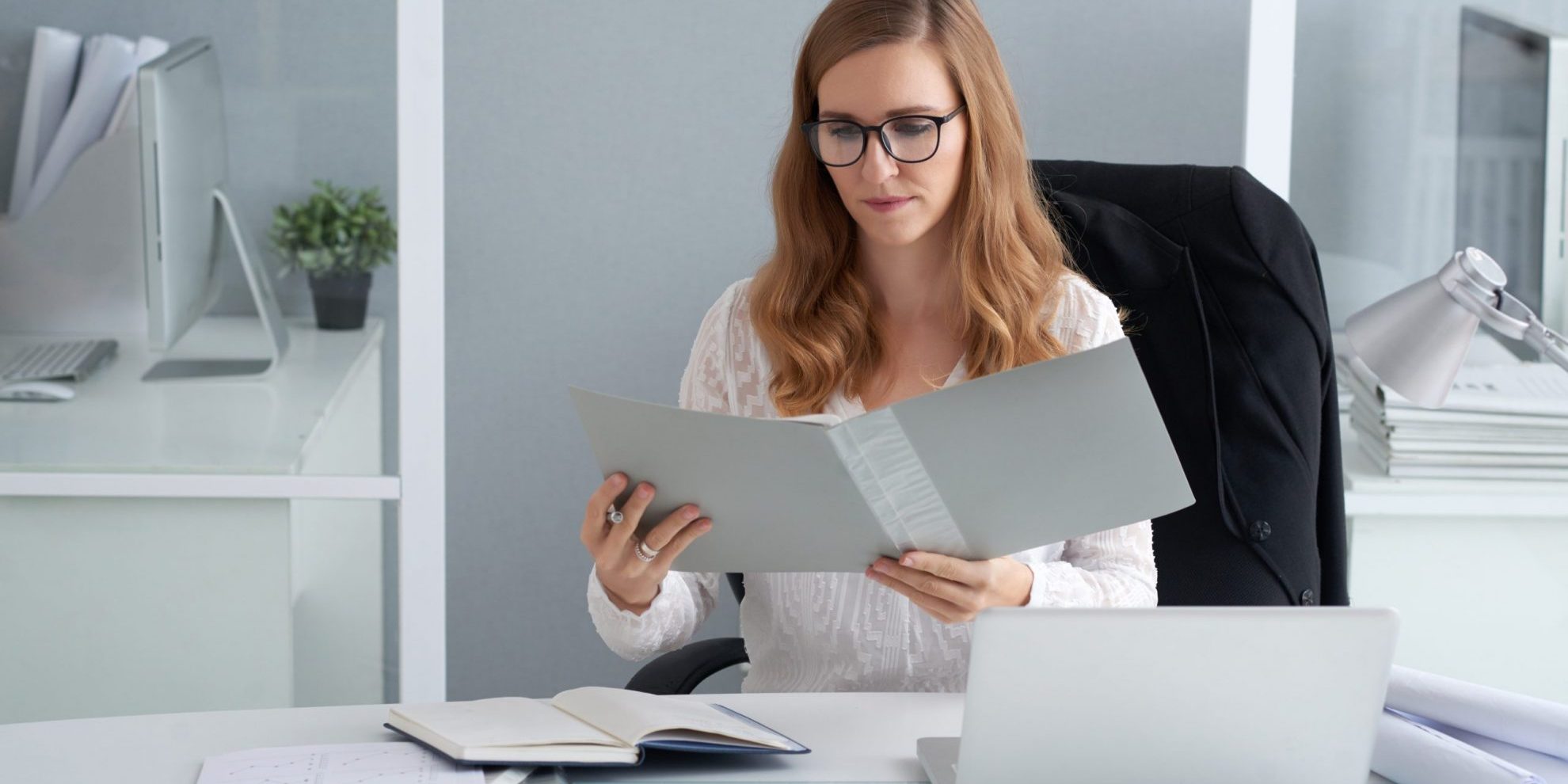 Woman looking at open folder illustrates blog "Are Background Checks Public Record?"