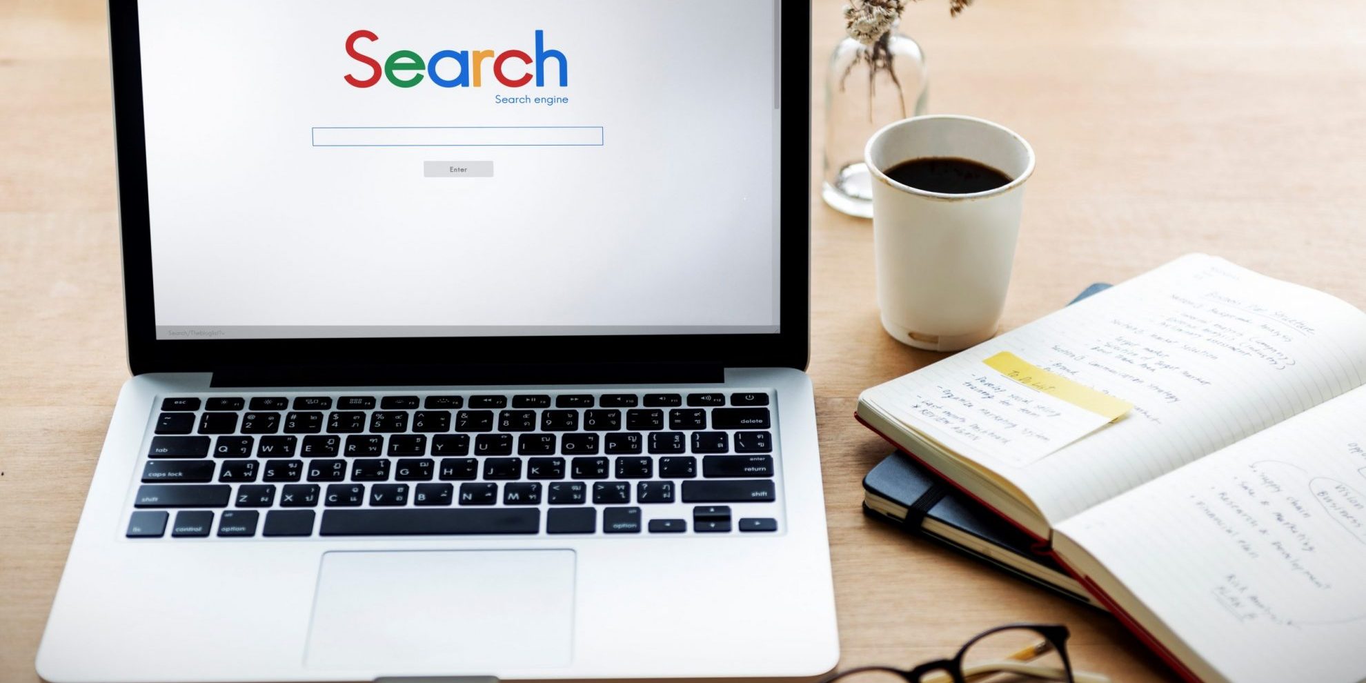 Photo of laptop with words "Search" displayed on the screen.