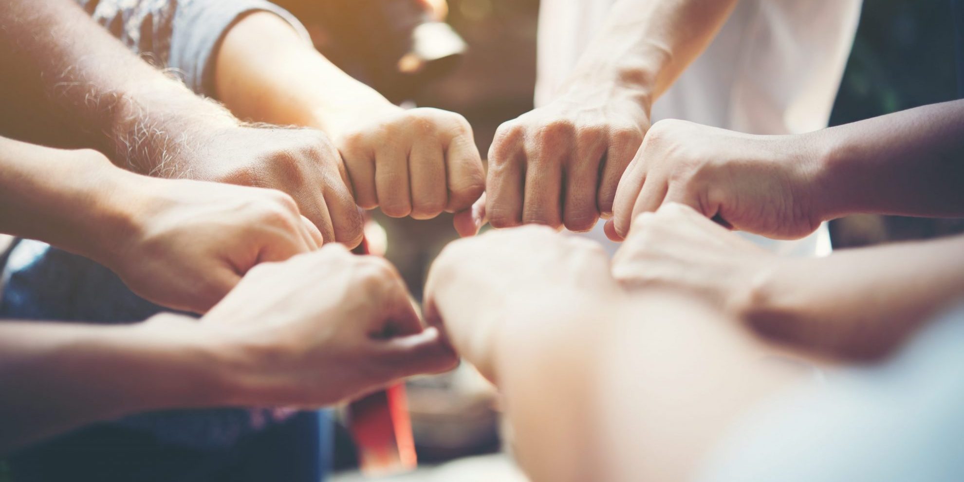 Photo of group of people touching fists.