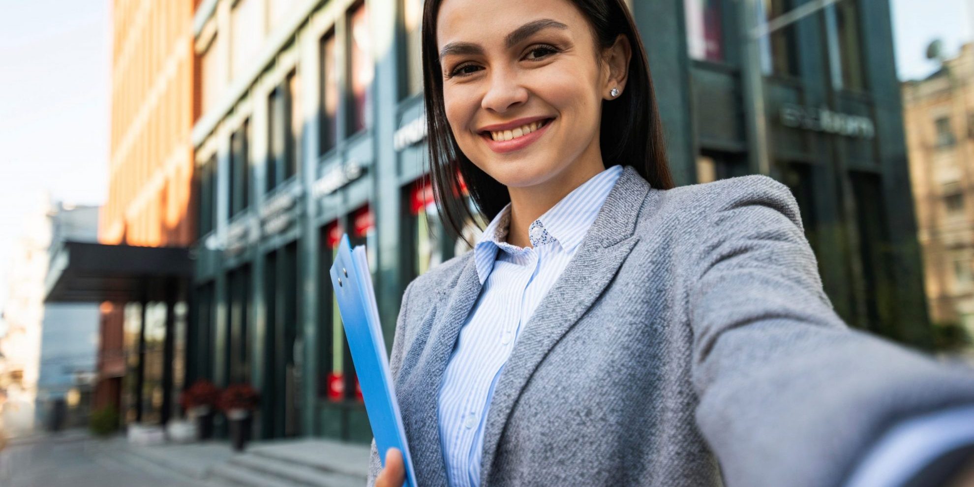 Smiling woman holding clipboard illustrates blog "5 Tips to Conduct Better Job Interviews"