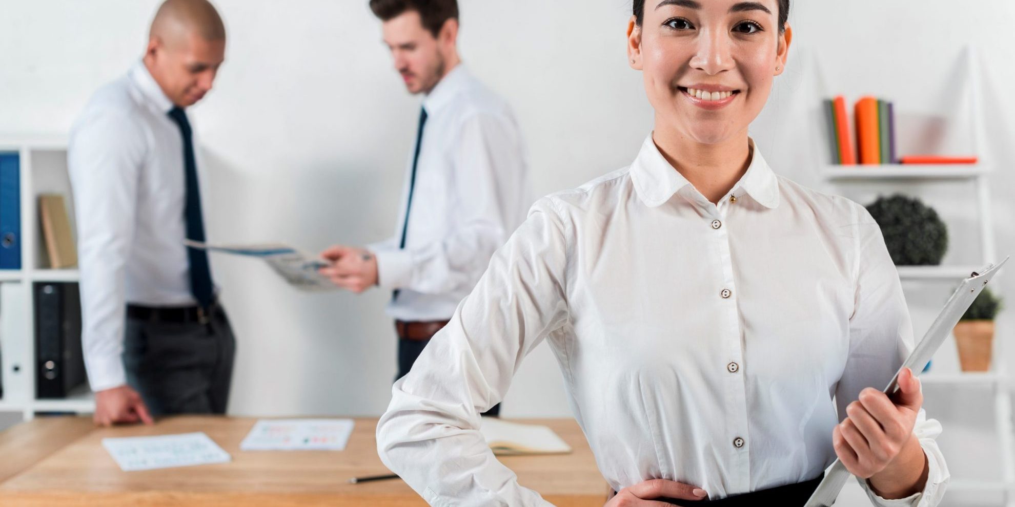 big-stay-FP Woman in business attire holding clipboard illustrates blog "Workplace Trends: What is the Big Stay?"
