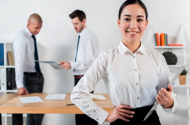 big-stay-FP Woman in business attire holding clipboard illustrates blog "Workplace Trends: What is the Big Stay?"