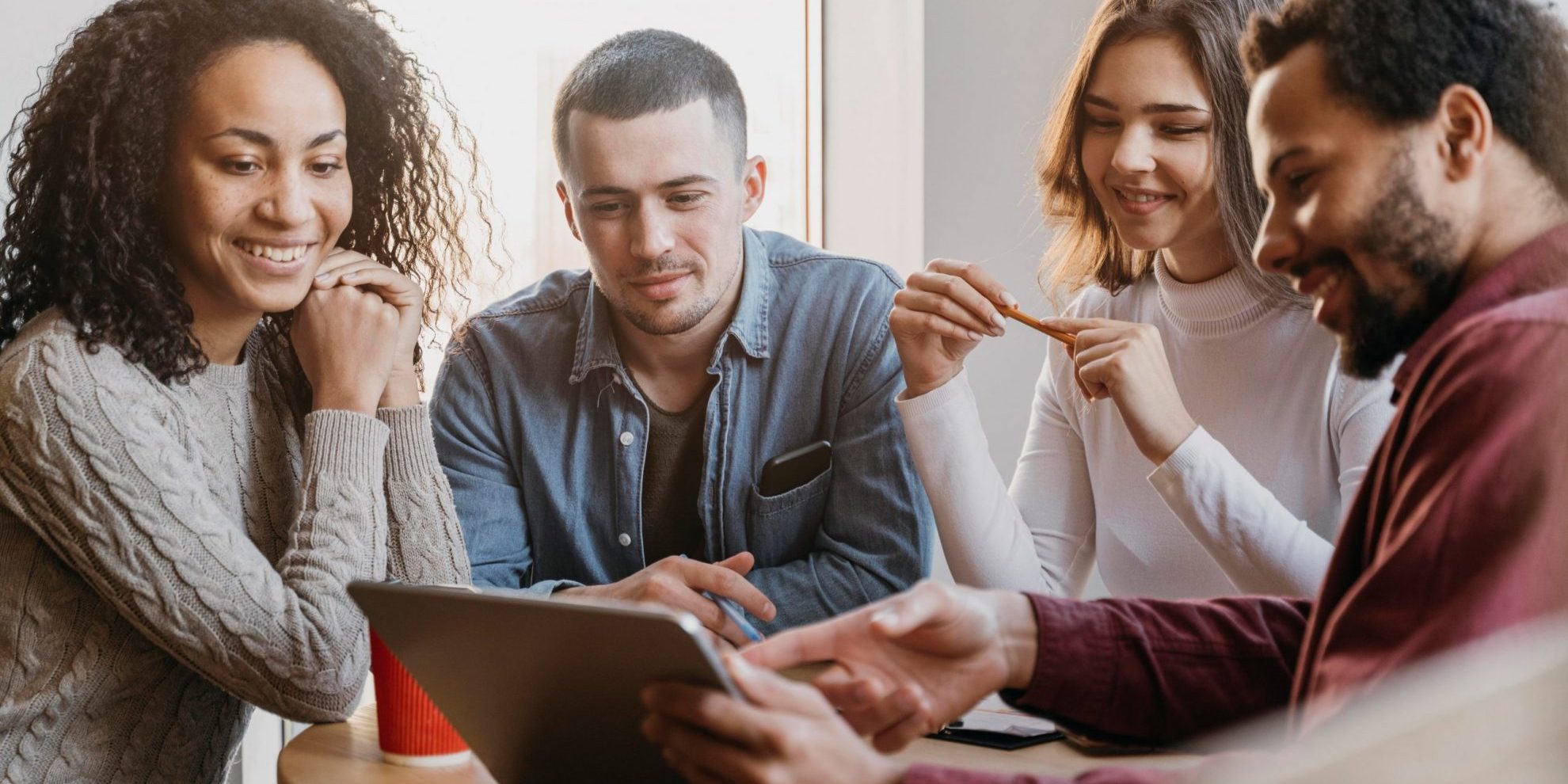 company-culture-fp Group of four people looking at tablet illustrates blog "How To Build a Strong Company Culture"