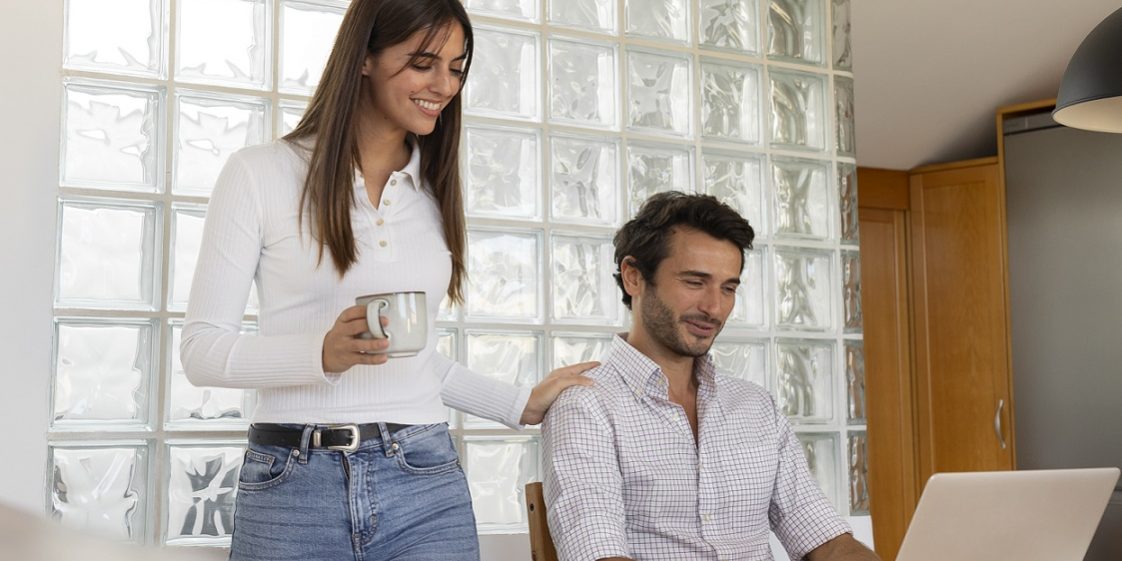 Woman and man looking at laptop illustrate blog "How to Reduce Hiring Costs Through Efficient Background Screening"